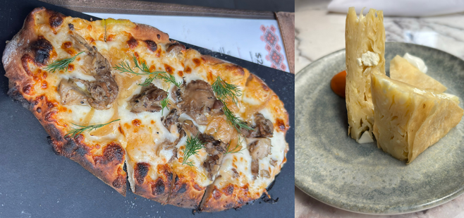 A large oval flatbread with mushrooms and white sauce and a flaky cheese pie.