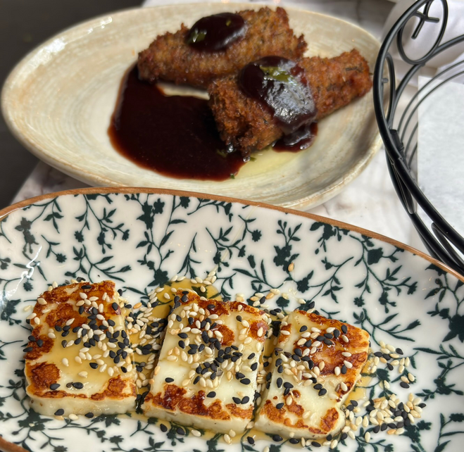 Fried croquettes filled with cheese and pepper on top and grilled cheese, topped with sesame seeds, below.