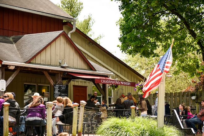 Exterior of Chaddsford Winery with people relaxing outdoors on the patio.