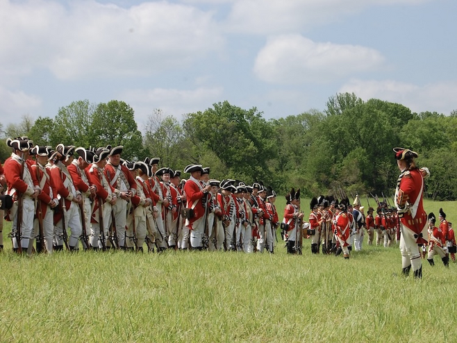 Reenactment of the Battle of Brandywine with soldiers dressed in red and white uniforms