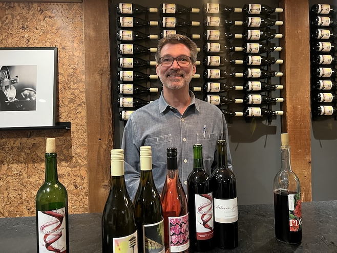 The Male owner of Chadsford Winery with wine bottles hosting a tasting