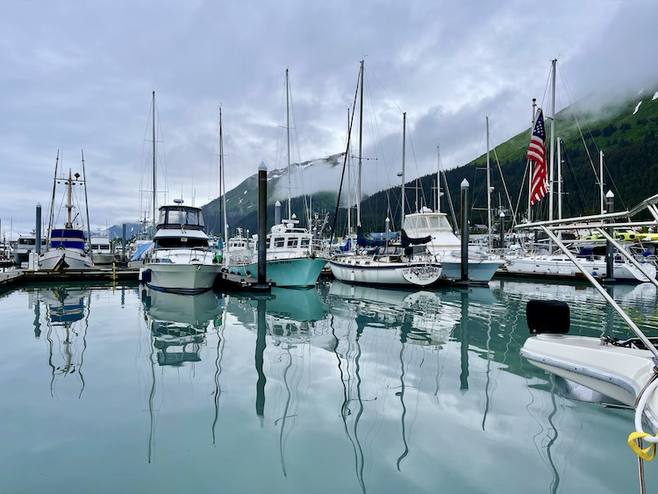 Boats in Seward Harbor with water reflections.