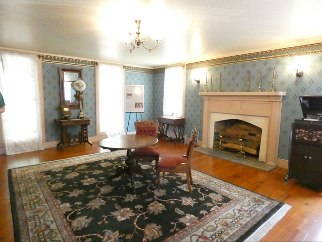 Gathering room in Chester Inn with fireplace and antique furniture.