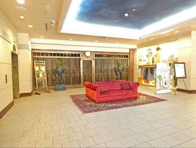 Lobby at Carnegie Hotel with red sofa in foreground and bronze statues to rear.