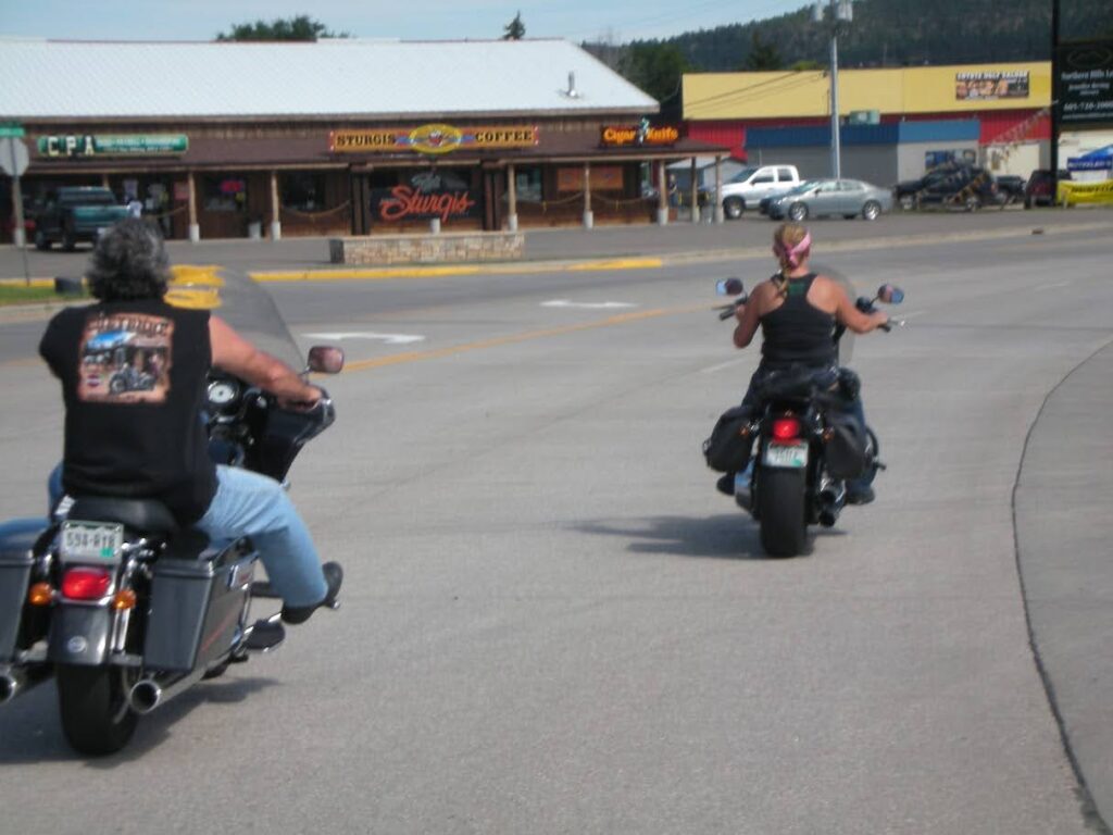 A man and woman on their Harleys riding into Sturgis SD for Bike Week