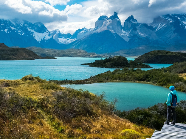 Young man views mountains and a lake in Chile.