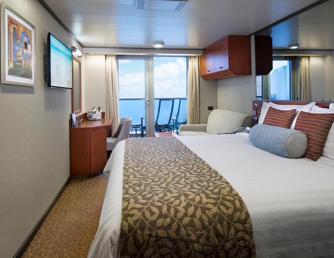 Stateroom with floor to ceiling windows and a private balcony