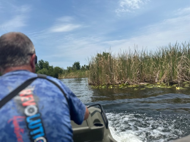 Man driving a boat with Revolution Adventures on their private lake. 