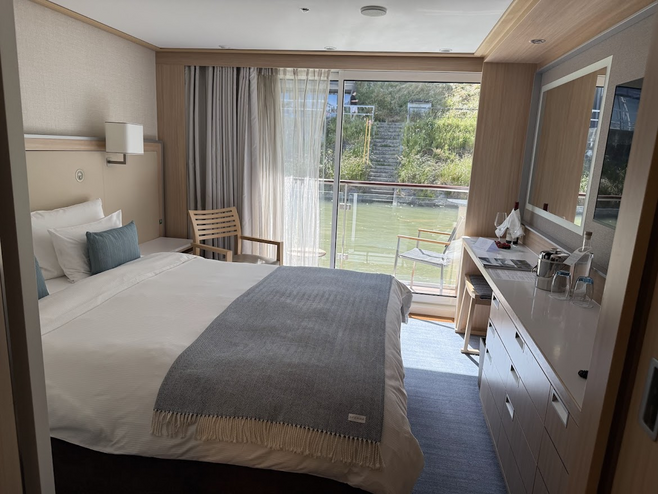 Room with a bed and a window overlooking water