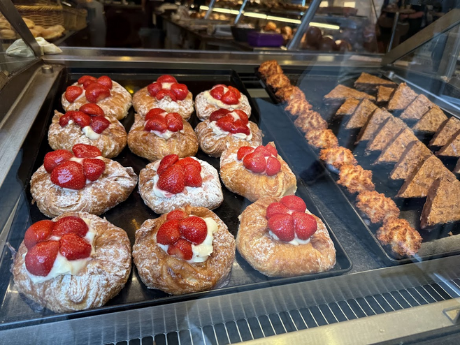 Pastries with strawberries in a bakery case