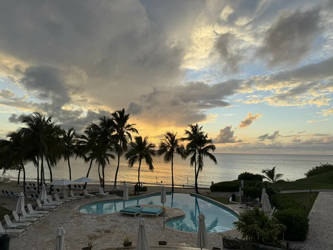 Ocean facing pool at sunset when the sun is behind the clouds.