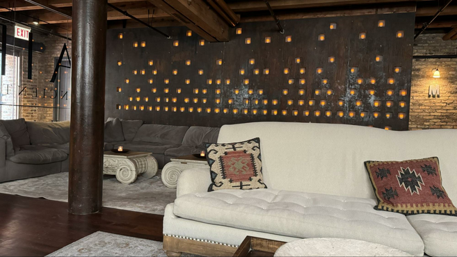 White and black couches in a bright room with a candle wall and decorative pillows. 