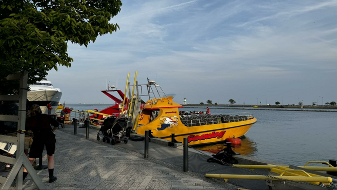 Yellow and red Seadog boat in a river next to docking materials at Navy Pier. 