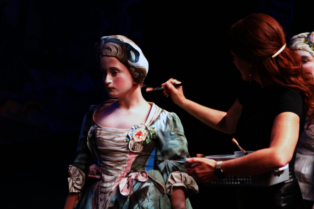 Artist painting a live human model for placement in a painting