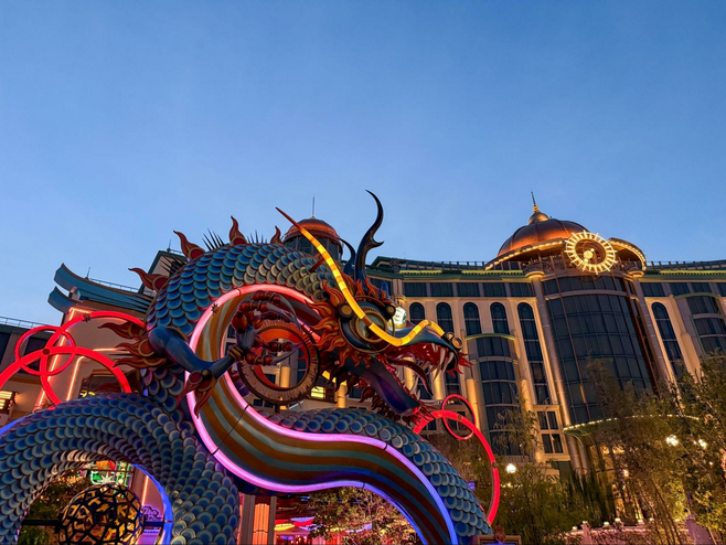 Epic Universe's Blue Dragon restaurant entrance with Helios Hotel in the background