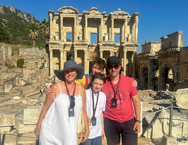 family of four standing in front of a the Library of Celsus