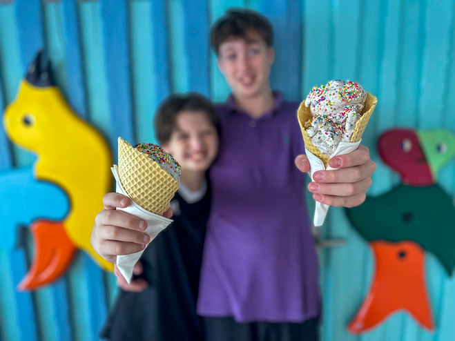 two boys smiling while holding ice cream cones with sprinkles at Fig and Honey