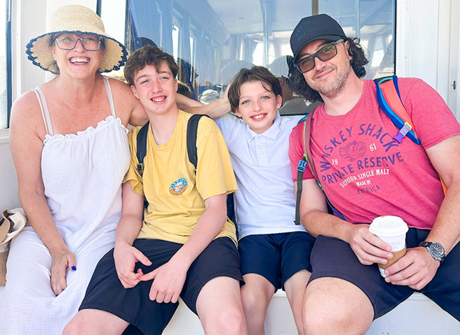 family of four on a tender on their way to Santorini