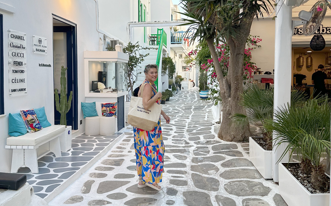 Woman holding a tote bag while shopping in the streets of Mykonos, Greece.