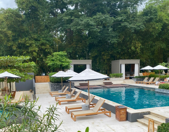 small pool with chaise lounges and cabanas