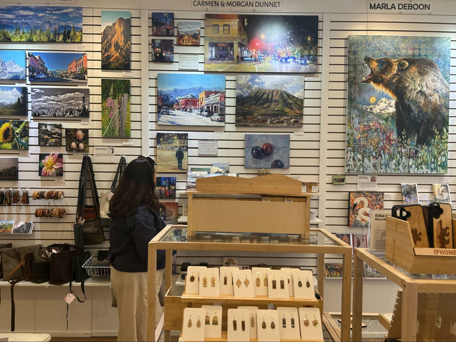Shopper looking at paintings at Fernie's Arts Co-op.