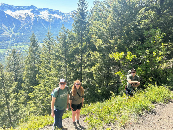 A father and daughter hike the mountains in Fernie BC with a guide.