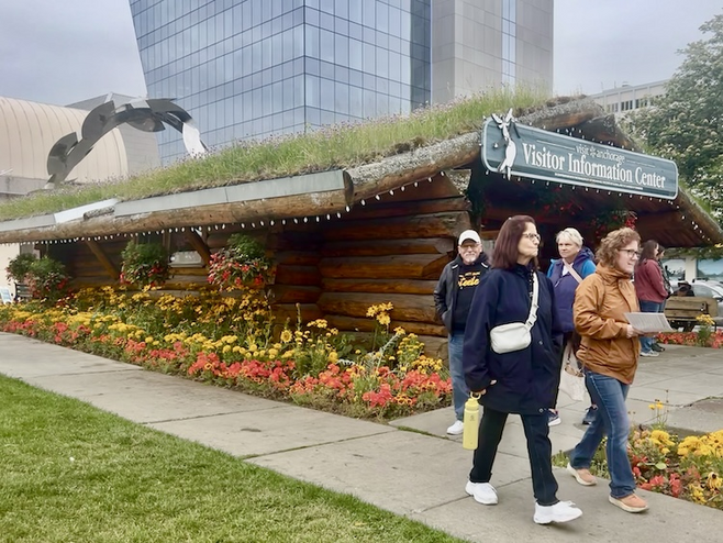 Anchorage Log Cabin Visitor Information Center with people exiting. 