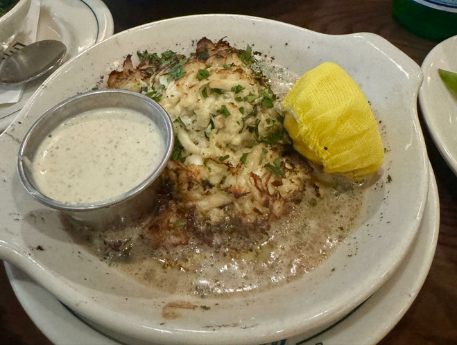 A crab cake with sauce and lemon from Little Mama's Italian restaurant in Charlotte NC