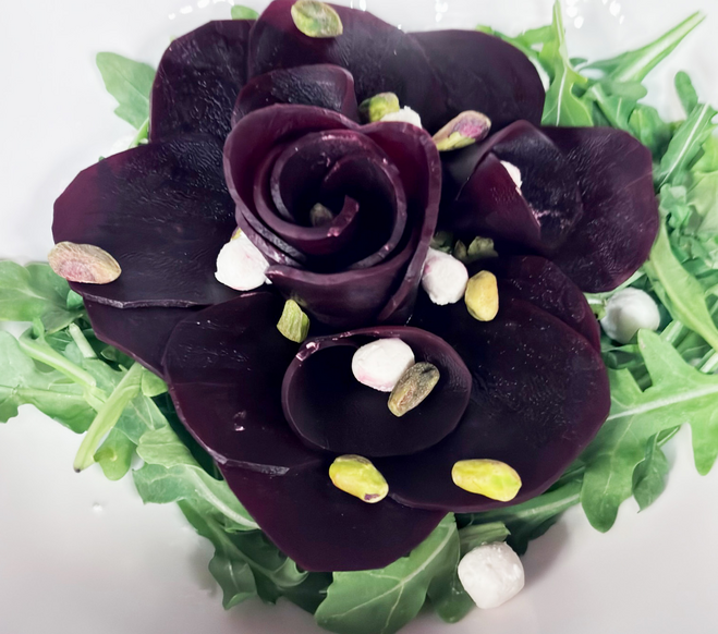 Beets forming a flower toppwed with goat cheese and pistachios.