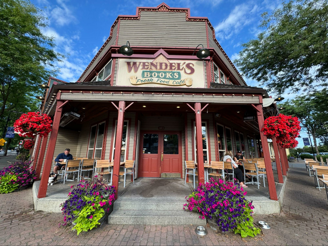 Vintage building with floral hanging baskets and planters.