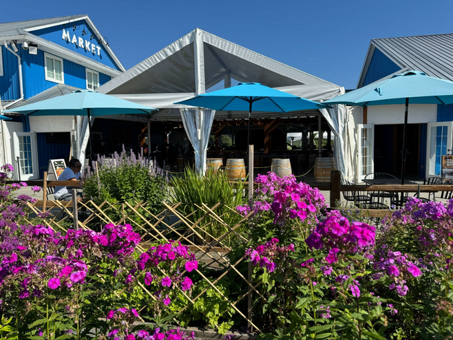 Two blue buildings with a covered outdoor space connecting the two.