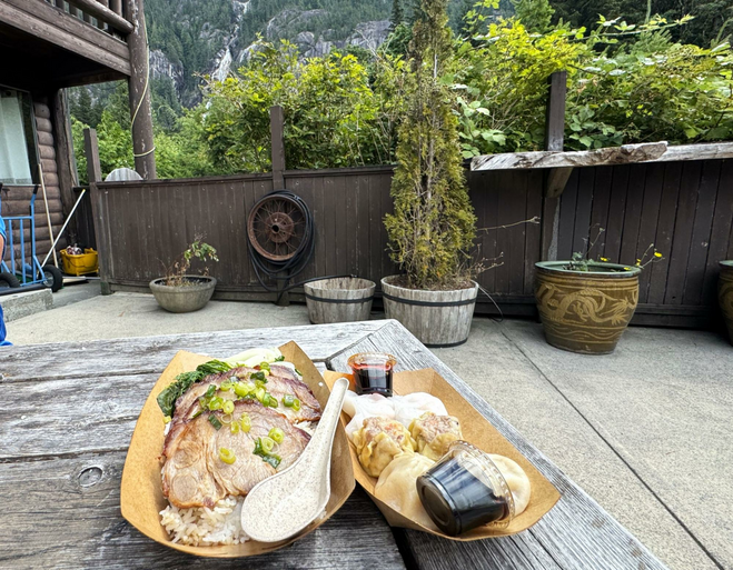 Patio with views of Shannon Falls in the distance. Picnic table with a pork entree and a serving of Dim Sum.
