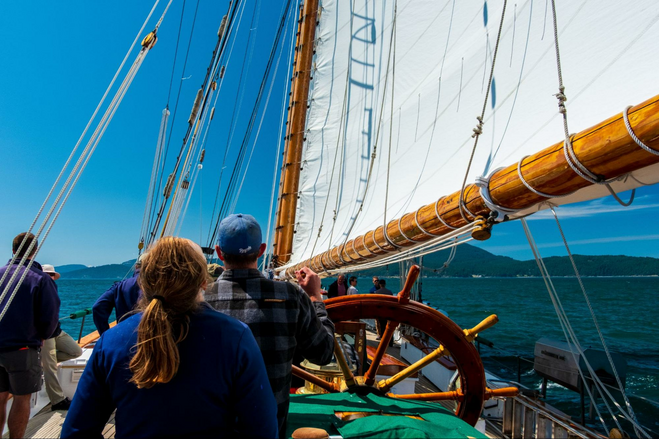 Passengers steering a tall ship.