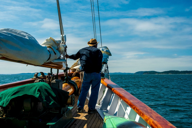 Man on the bow of a tall ship.