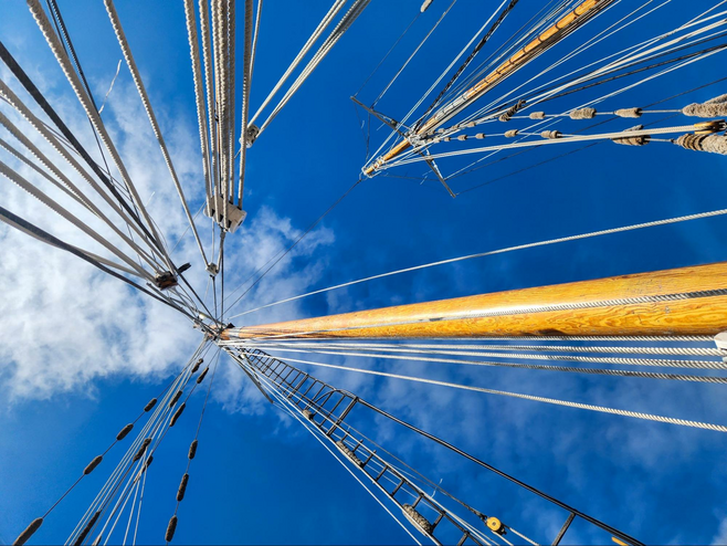 The rigging of a tall ship against the sky.