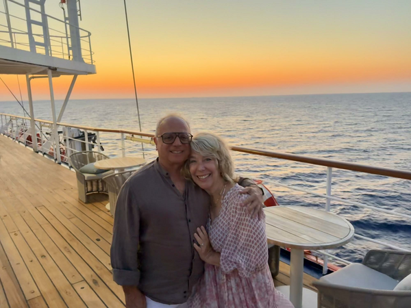Couple on deck of ship enjoying sunset.