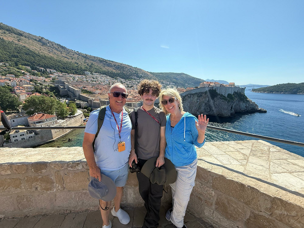 Family on top of city wall with harbor in background.