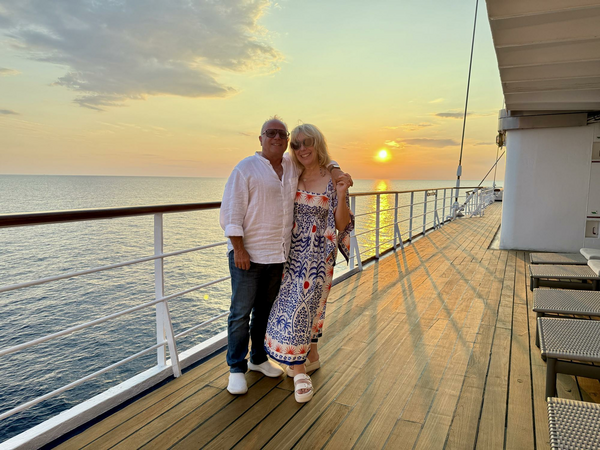 Author and husband on ship with sunset.