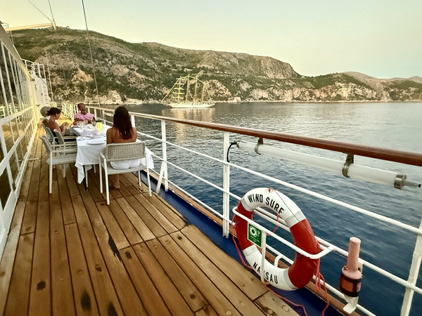 Looking down the side of a ship with small group of diners enjoying a meal.