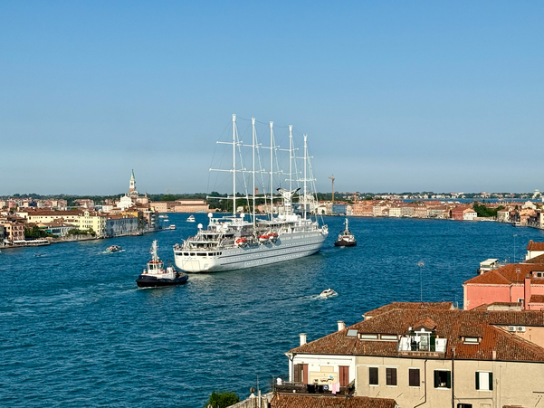 A small cruise ship being tugged out of Venice Italy