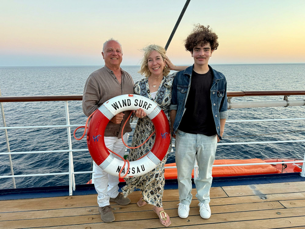 Family on ship deck with lifesavor ring aboard a small shp