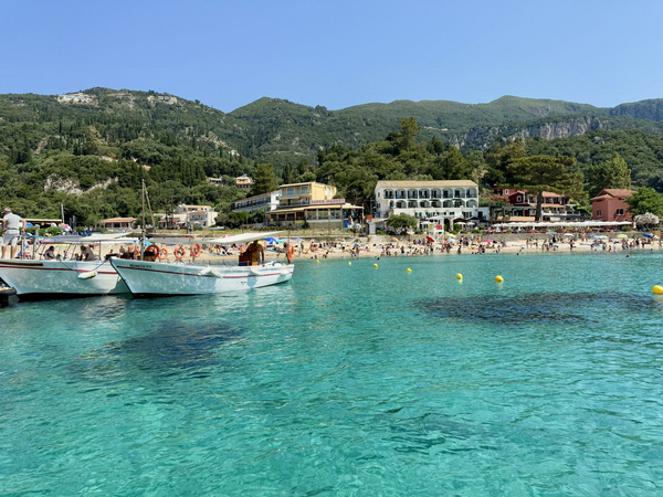 Beaches, boats, and beachgoers with turquoise blue water.