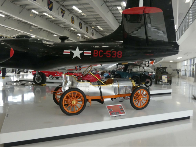 A 1908 Bugatti Type 10 sitting in front of The Douglas A-26B Invader in Lyon air Museum