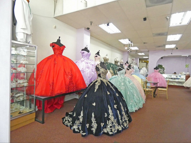 Red, black and various pastel quinceañera gowns on display.