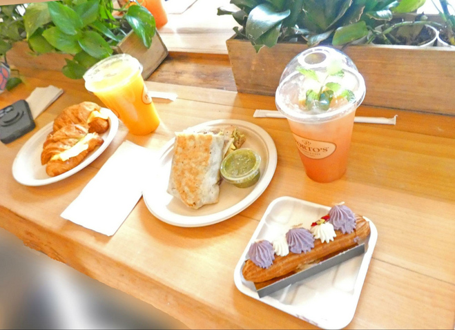 Three plates of food and two drinks on counter.