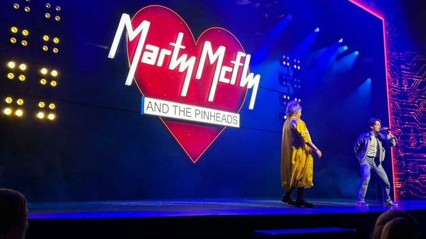 Heart screen with Marty McFly And The Pinheads etched into it with two stage performers one in a yellow jacket and the other in a denim set. 