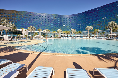 Large pool with palm trees and Universal Terra Luna Resort in the background.