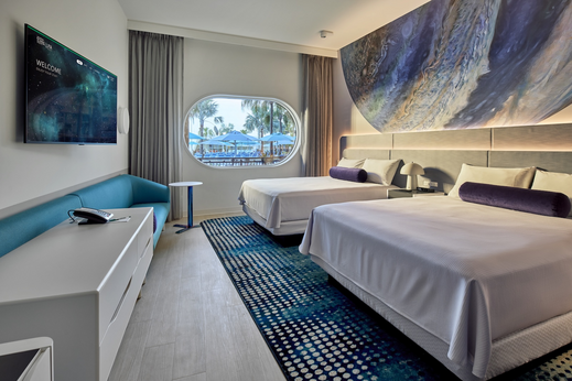 Universal Terra Luna Resort guest room with blue planetary mural above two queen-size beds.