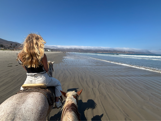 The author, Hudson riding horseback on Playa Blanca with stunning beach views and crystal blue water.