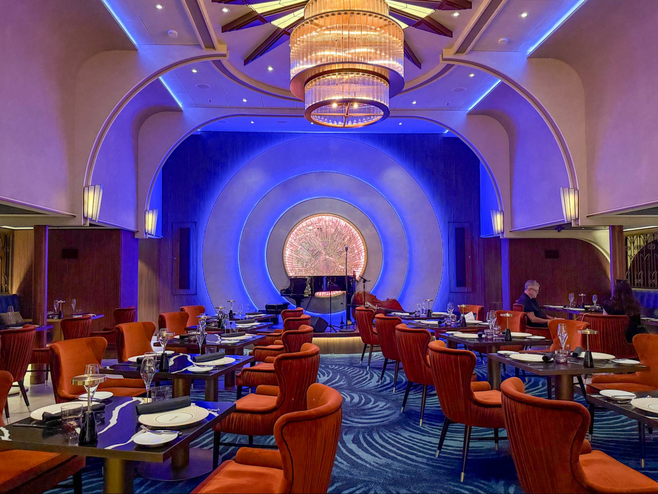 Supper club restaurant with small tables and piano on stage